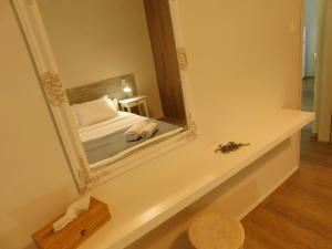 espejo en un estante en una habitación con cama en Villa Anastasia, en Kalamaki