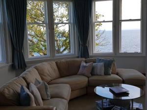 a living room with a couch and a table and windows at Crail House Apartments in Crail