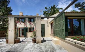 a house with green shutters on the side of it at Villa Can Canaver in Pollença