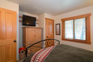 a bedroom with a bed and a flat screen tv at North Star - Ski View Condo in Truckee