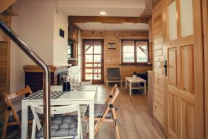 a kitchen and dining room with a table and chairs at Osada Bóbrka nad Soliną in Solina +59 photos