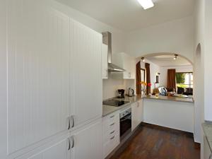 a white kitchen with white cabinets and a sink at Sao Rafael Holidays in Albufeira