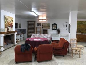 sala de estar con mesa, sillas y chimenea en Casa Marin, en Esparragalico
