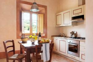 una cocina con una mesa con un bol de fruta. en Chiarentana en Chianciano Terme