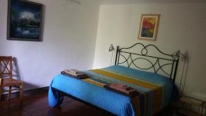 a bedroom with a bed with a colorful blanket at Il Giardino dei Merli in Bussoleno