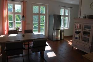 a kitchen with a wooden table and a refrigerator at Jasmundhus in Neddesitz