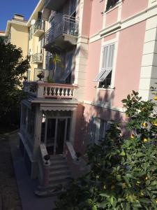 Edificio rosa con escaleras y balcón en Hotel Lucciola en Bordighera
