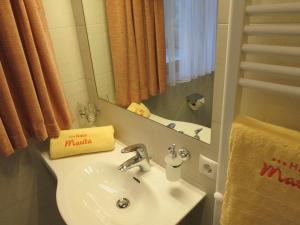 W łazience znajduje się biała umywalka i lustro. w obiekcie Haus Marita w mieście Oetz