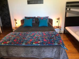 - une chambre dotée d'un lit avec un couvre-lit floral dans l'établissement l'Orangerie de La Pontête, à Vayres