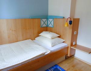 a bedroom with a bed with a wooden head board at A Part of Eden in Krumpendorf am Wörthersee