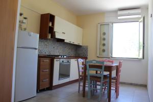 SoletoにあるIl Giardino di Albaのキッチン(白い冷蔵庫、テーブル、椅子付)