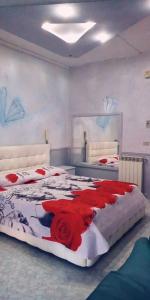 sypialnia z 2 łóżkami z czerwonymi kwiatami w obiekcie Hotel Napoleon-Cuore w mieście Qualiano