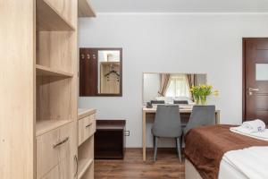 1 dormitorio con escritorio, 1 cama y espejo en Villa Baltic Dream, en Międzyzdroje