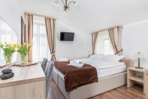 um quarto de hotel com uma cama, uma secretária e uma janela em Villa Baltic Dream em Międzyzdroje