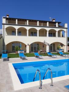 a hotel with a swimming pool in front of a building at Villa Benvenuto in Costermano