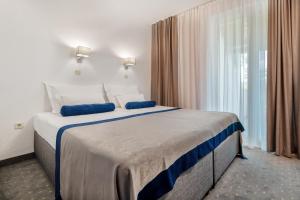 a bedroom with a large bed with blue pillows at Apartments Tamaris in Neum