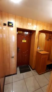 Camera con porta in legno e pavimento piastrellato. di Apartment on Lenina 85 a Uryupinsk