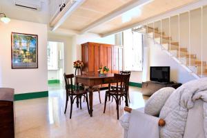 a living room with a dining room table and chairs at La Ciucciara Holiday Homes in Massa Lubrense