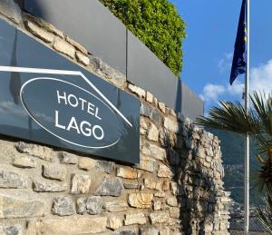 ein Schild für ein Hotel Lago auf einer Steinmauer in der Unterkunft Hotel Lago in Torno