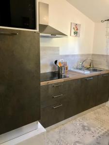 a kitchen with brown cabinets and a sink at Place San Pantaléo : jolie maison sarde authentique in San Pantaleo