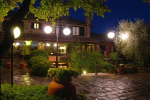 una casa con luci di strada e un cortile di notte di Casanova - Panoramic Rooms and Suites a San Quirico dʼOrcia