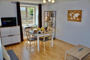 a living room with a table and chairs and a television at Royal Confort in Bayeux