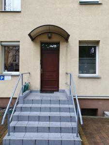 a set of stairs leading to a door of a building at Biedronka- samodzielny apartament dla 3 osób z miejscem parkingowym in Sopot