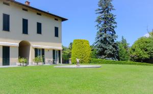 a large yard with a fountain in front of a building at Bel Faggio Rosso apartment in Menaggio