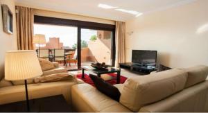 sala de estar con sofá y TV en Nueva Galera, en Estepona