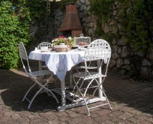 un tavolo bianco con due sedie e un tavolo con fiori di Camera a cinque minuti dal mare a Portoferraio