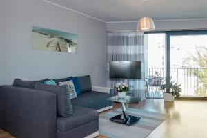 sala de estar con sofá y TV en Horyzont by Baltic Home en Międzyzdroje