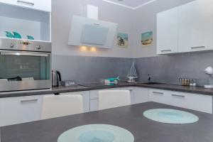 a kitchen with white cabinets and a counter top at Horyzont by Baltic Home in Międzyzdroje