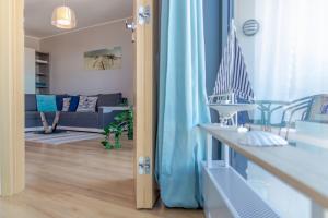 sala de estar con cortinas azules y sofá en Horyzont by Baltic Home en Międzyzdroje