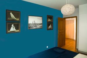 a room with a blue wall with pictures on it at AHOY PUCK apartament przy plaży z widokiem na morze in Puck