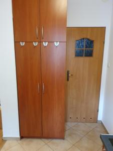 a pair of wooden cabinets in a room with a door at Biedronka- samodzielny apartament dla 3 osób z miejscem parkingowym in Sopot