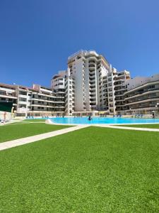 a large grassy field in front of tall buildings at Algarve Vacations Flat in Albufeira