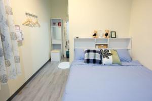 台南的住宿－333巷日宿 ，一间卧室配有一张带蓝色床单和枕头的床。