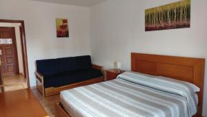 a bedroom with a bed and a blue chair at Castelos da Rocha in Portimão +35 photos