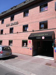 ein rotes Backsteingebäude mit einem Hotel-Schild darauf in der Unterkunft Lys Hôtel in Halluin