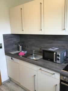 a kitchen with a sink and a microwave at Haus Dünenblick in Borkum