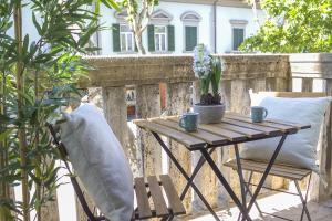 una mesa de madera y una silla en el balcón en Accanto Al Centro B&B, en Prato