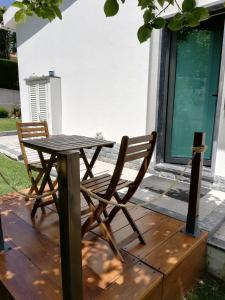 a wooden table and two chairs on a wooden deck at Moradia no Seixal Ericeira in Ericeira