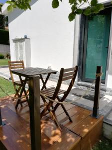 una mesa de madera y 2 sillas en una terraza de madera en Moradia no Seixal Ericeira, en Ericeira
