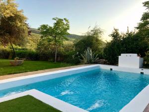 a swimming pool in the yard of a house at Hotel Finca Aldabra in Pinos Genil