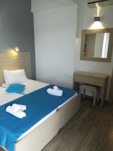 ein Schlafzimmer mit einem Bett mit zwei Handtüchern darauf in der Unterkunft View Port in Skiathos-Stadt