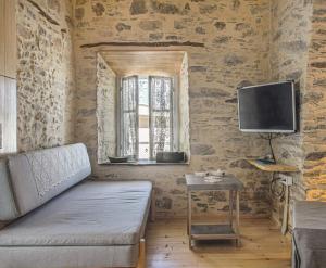 uma sala de estar com um sofá, uma televisão e uma mesa em Azura, traditional residence in Ano Syros em Ano Syros
