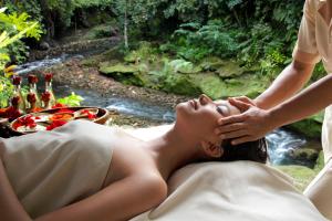 Eine Frau, die auf einem Bett liegt und eine Massage bekommt. in der Unterkunft Hotel Tjampuhan Spa in Ubud