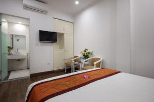 um quarto com uma cama grande e uma casa de banho em Busan Hotel em Hanói