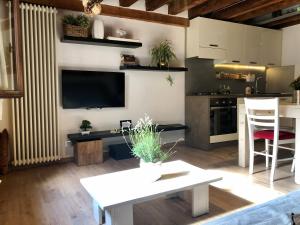 a living room with a white table and a kitchen at Vivi Vicenza in Vicenza