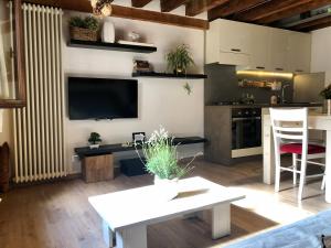 a living room with a white table and a kitchen at Vivi Vicenza in Vicenza +23 photos